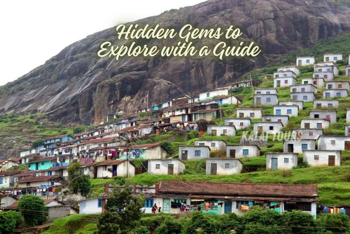 Scenic hillside village nestled against rocky terrain in Ooty, showcasing the region's unique architecture and cultural charm. Highlighting Kalai Tours in Coonoor, Ooty, and their guide services to uncover hidden gems and local traditions. Ideal for travelers seeking authentic and immersive experiences in the Nilgiris